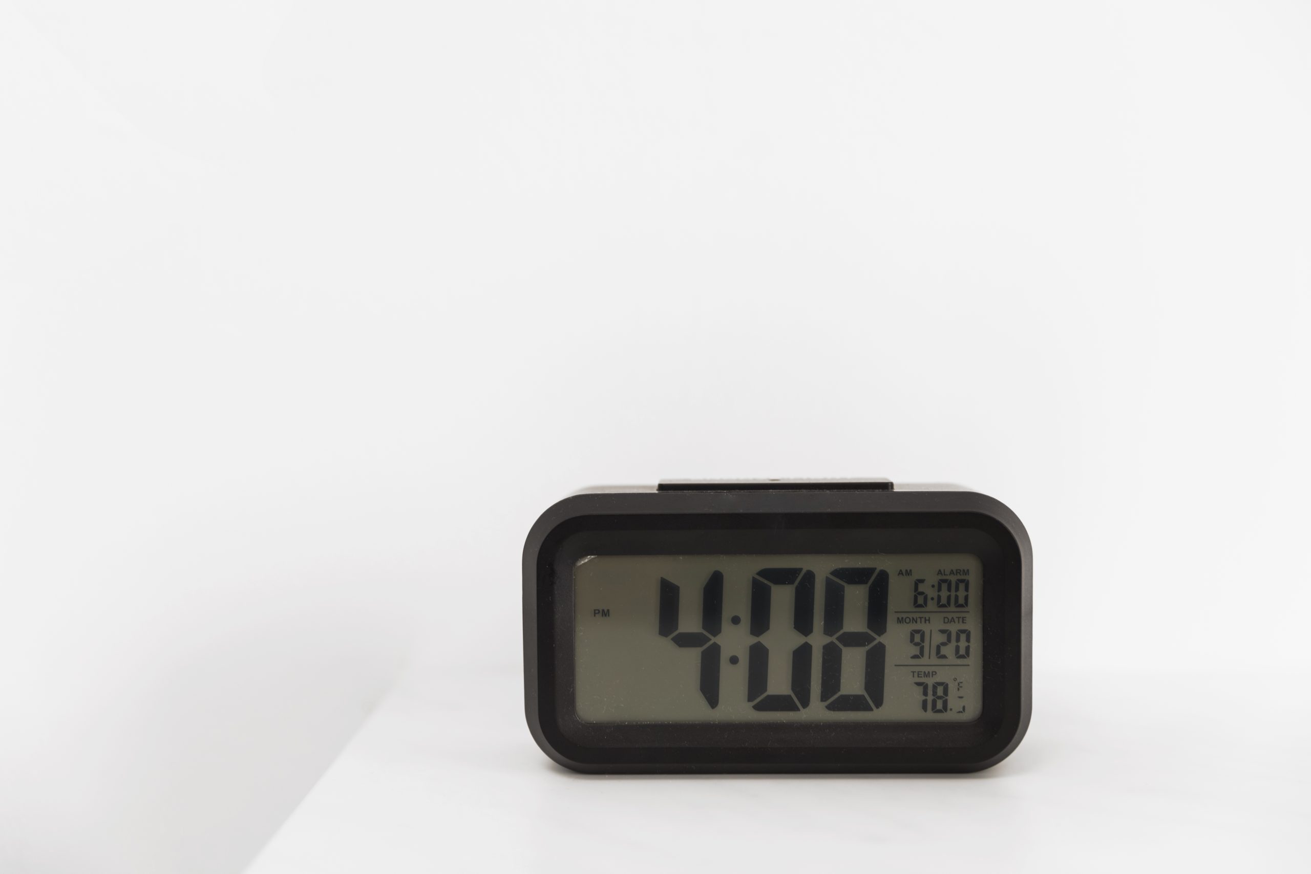 Horloge numérique lumineuse dans la pénombre, illustrant le phénomène des heures miroirs comme 21h21