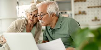 Couple de retraités examinant leurs documents financiers à la maison