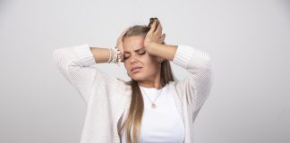 Femme visiblement anxieuse, les mains portées au visage, illustrant une montée d'angoisse