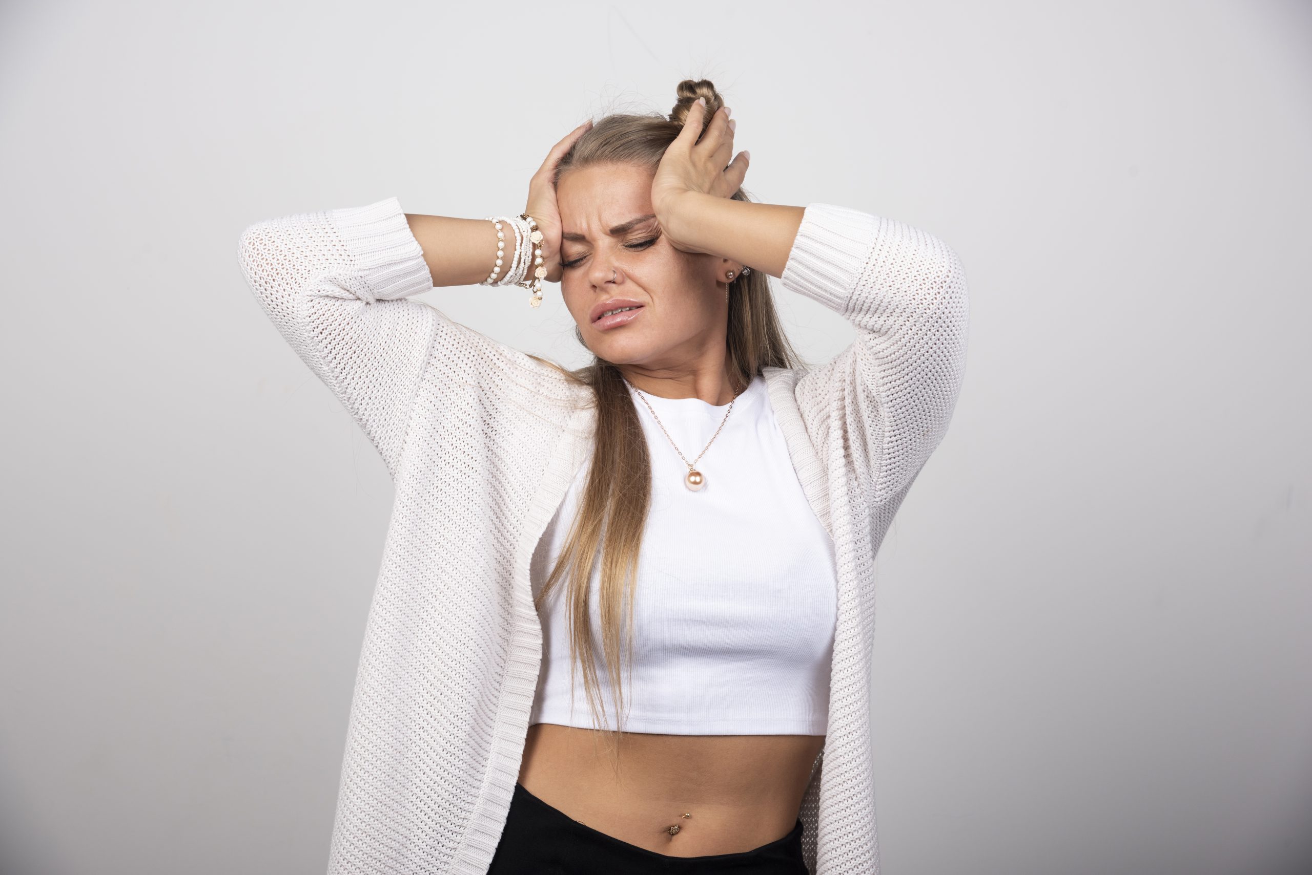 Femme visiblement anxieuse, les mains portées au visage, illustrant une montée d'angoisse