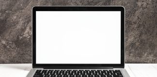 Ordinateur portable ouvert affichant un ecran blanc sur un bureau