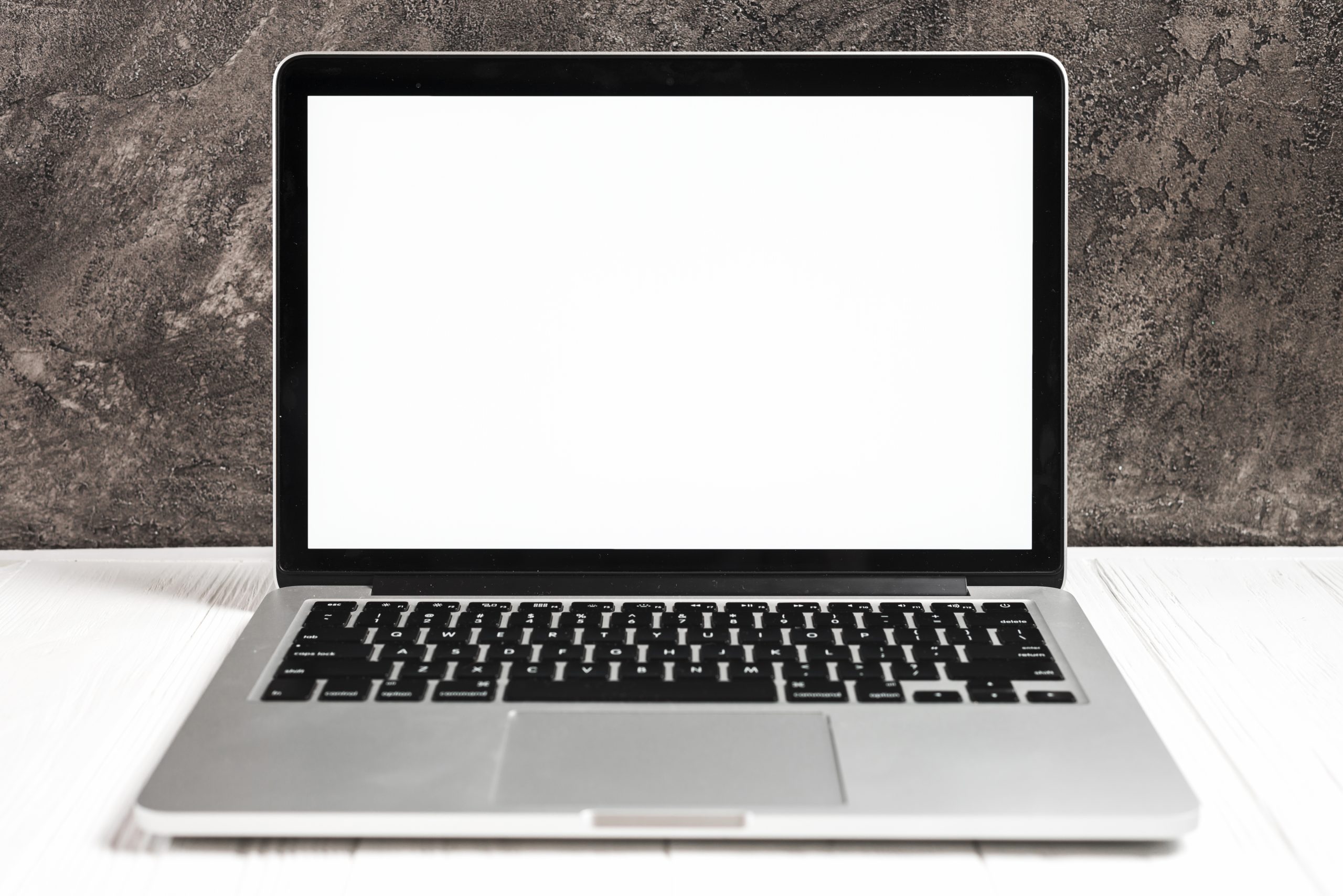 Ordinateur portable ouvert affichant un ecran blanc sur un bureau