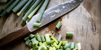Poireaux émincés sur une planche à découper, prêts pour la fondue