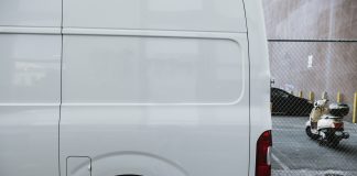 Fourgon utilitaire blanc stationne dans une rue etroite, portes arriere fermees