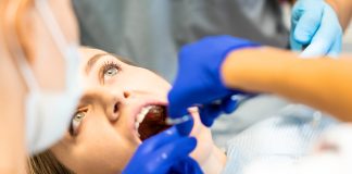 Dentiste soignant une molaire d'un patient au cabinet dentaire