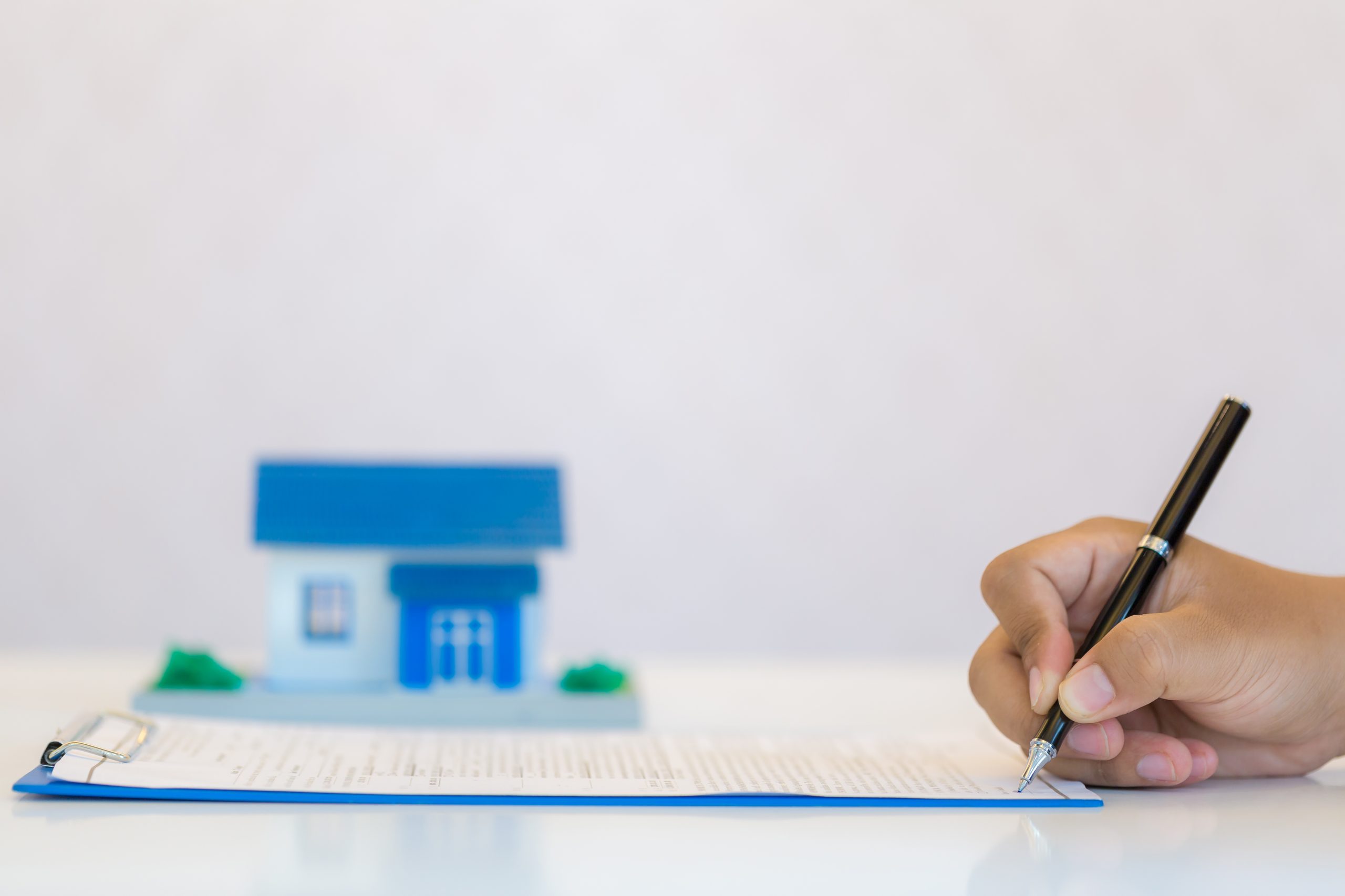 Main remplissant un document administratif de type quittance de loyer sur un bureau